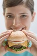 Young woman holding cheeseburger