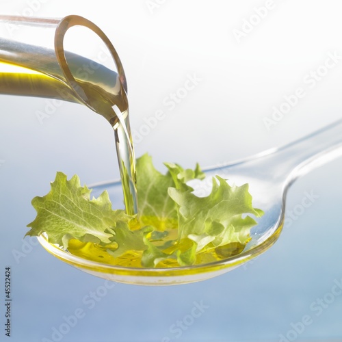 Photo: Oil running onto lettuce leaf on spoon Oil running onto lettuce leaf on spoon