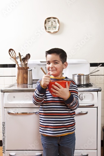 Photo: Six Year Old Boy Stirring Bowl In Front of Stove in Kitchen Six Year Old Boy Stirring Bowl In Front of Stove in Kitchen