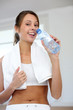Cheerful fitness girl drinking water after exercising