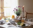 Laid breakfast table with baked goods, juice and fruit