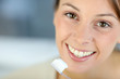 Closeup on woman's toothy smile brushing her teeth