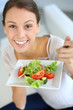 Closeup of cheerful woman eating fresh salad
