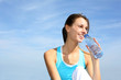 Thirsty fitness girl holding bottle of water