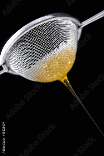 Photo: Honey running through sieve Honey running through sieve