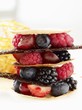 A tower of fresh berries and caramel sheets
