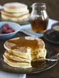 Stack of Buttermilk Pancakes with Syrup and Powdered Sugar; Bite Taken Out