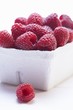 Raspberries in cardboard punnet (close-up)