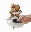 Brown mushrooms being washed in a sieve