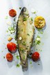 Fried trout with herbs, garlic, tomatoes and lemons
