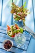 Two summer salads, olives and a glass of white wine