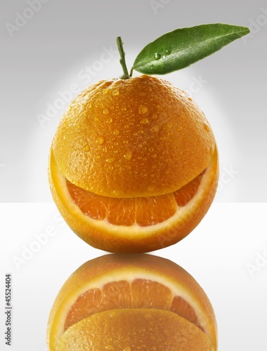 Photo: One orange with a slice taken out of it One orange with a slice taken out of it