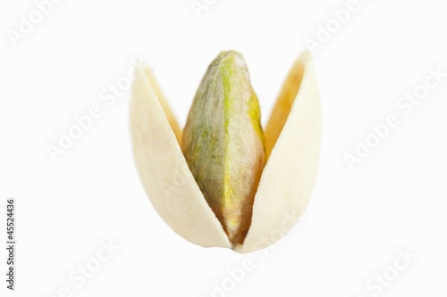 Photo: An opened, toasted pistachio against a white background An opened, toasted pistachio against a white background