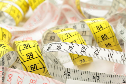 Photo: Various tape measure as background. Various tape measure as background.