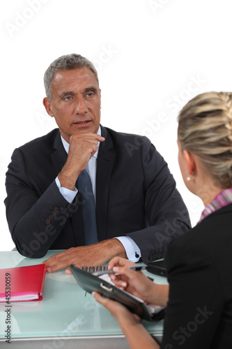 Photo: Businessman sitting with his PA Businessman sitting with his PA