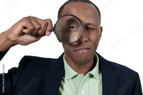 Photo: Black Man Looking through a magnifying glass Black Man Looking through a magnifying glass