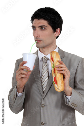 Photo: smart pensive businessman having quick lunch break smart pensive businessman having quick lunch break