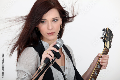 Photo: Woman with microphone and guitar Woman with microphone and guitar