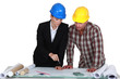 Two architects examining plans