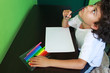 Little boy is wondering what to draw on his white piece of paper