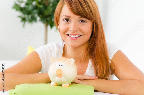 Photo: junge frau mit sparschwein junge frau mit sparschwein