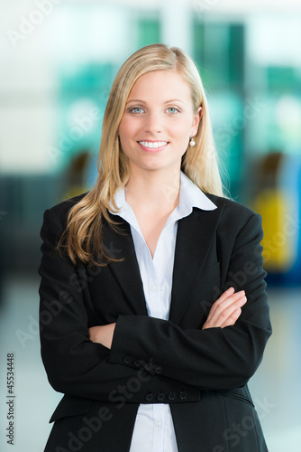 Photo: Lächelnde Business-Frau mit verschränkten Armen Lächelnde Business-Frau mit verschränkten Armen