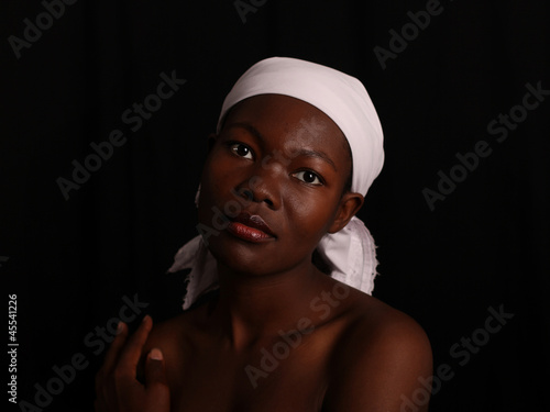 Photo: Afrikanerin mit weißem Kopftuch vor schwarzem Hintergrund Afrikanerin mit weißem Kopftuch vor schwarzem Hintergrund