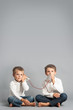 Young brothers talking with tin can telephone.