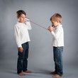 Young brothers talking with tin can telephone.