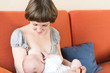 Young beautiful Mother breastfeeding her newborn baby
