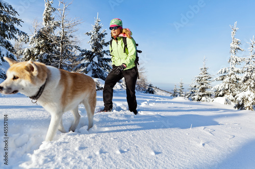 Photo: Woman hiking in winter with dog Woman hiking in winter with dog