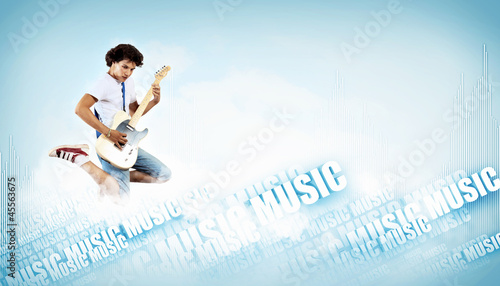 Photo: young man playing on electro guitar and jumping young man playing on electro guitar and jumping