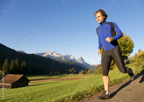 Photo: Jogger in der Natur mit Bergen im Hintergrund Jogger in der Natur mit Bergen im Hintergrund