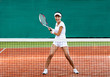 Woman in sportswear plays tennis at training