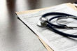 Stethoscope on medical billing statement on table