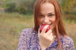 portrait of young woman holding red apple in hand