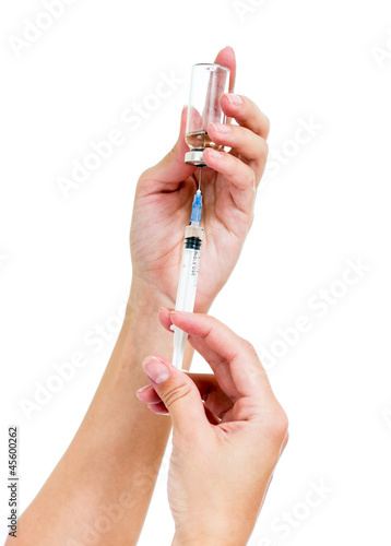 Photo: Syringe with a medicine in a female hands, isolated on white Syringe with a medicine in a female hands, isolated on white