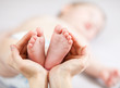 mother hands holding small baby's feet