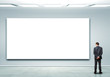Photo: Business person standing near a blank billboard Business person standing near a blank billboard
