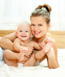 Mother and daughter play in the bedroom