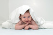 Baby unter Decke lachend