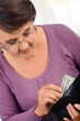 Photo: Elderly woman holding wallet with money Elderly woman holding wallet with money