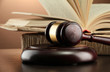 wooden gavel and books on wooden table,on brown background