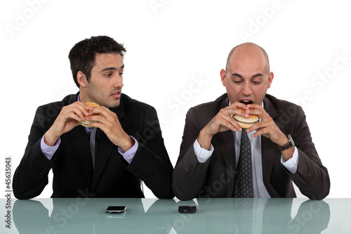 Photo: businessmen eating hamburgers businessmen eating hamburgers