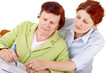 Senior woman writing checks with daughter help