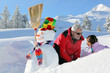 Father and daughter with snowman