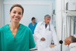 Smiling nurse standing in a hospital room