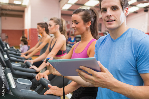 Photo: Male gym instructor with women on treadmills Male gym instructor with women on treadmills
