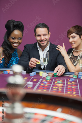 Photo: Man playing roulette with two women Man playing roulette with two women