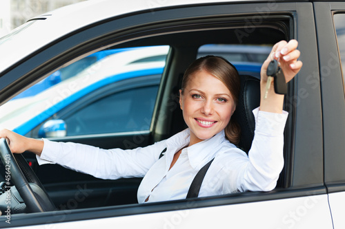 Photo: woman sitting in car and showing the car keys woman sitting in car and showing the car keys